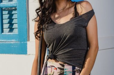 woman in grey sleeveless top leaning on wall