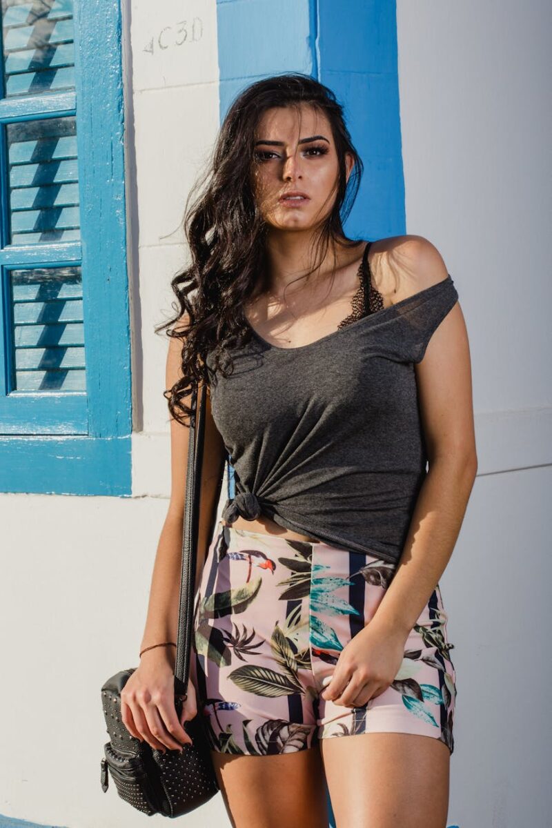 woman in grey sleeveless top leaning on wall