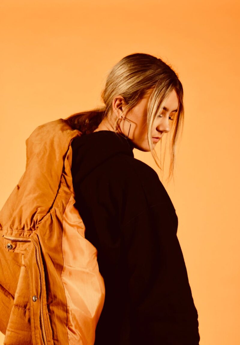 woman wearing black coat holding brown jacket