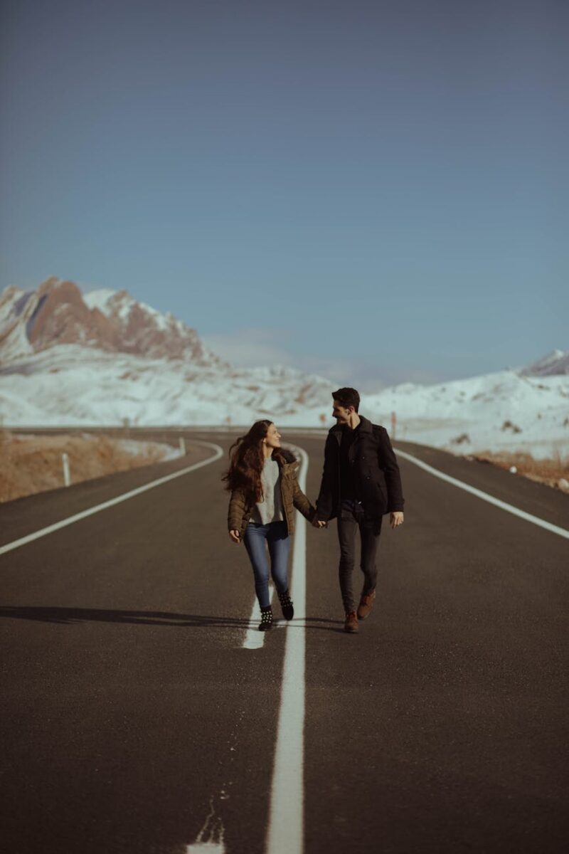 man and woman walking on road