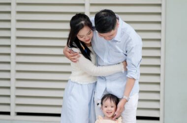 a family is posing for a photo in front of a building