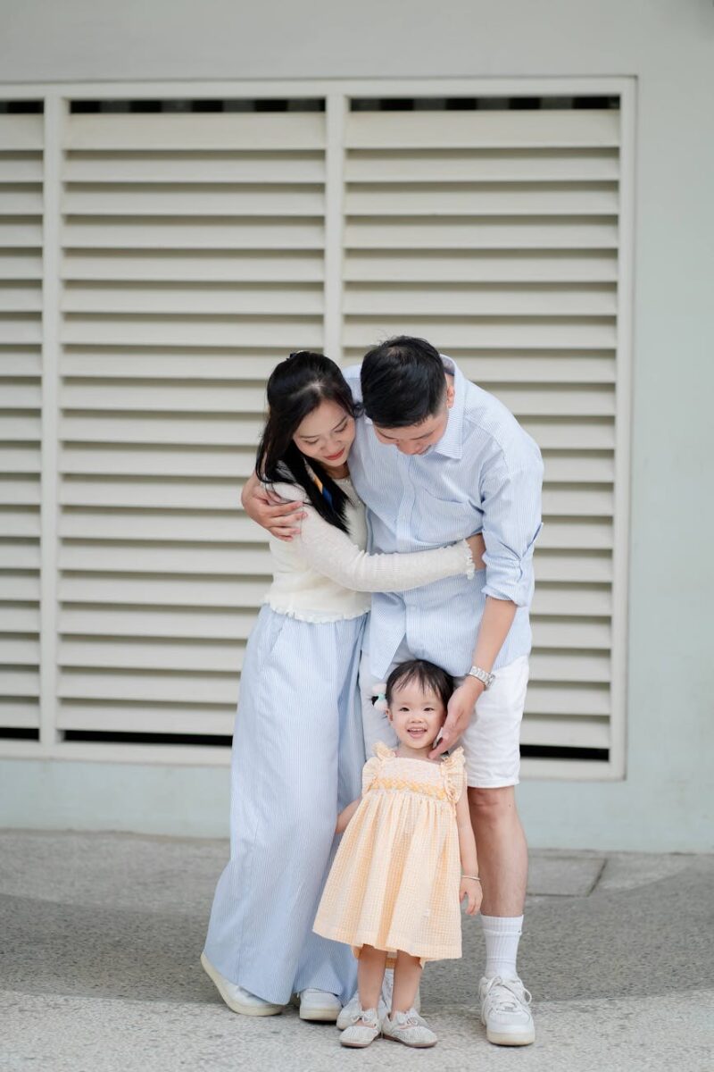 a family is posing for a photo in front of a building