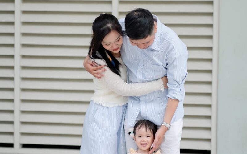 a family is posing for a photo in front of a building