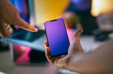 hands pointing at smartphone with gradient screen