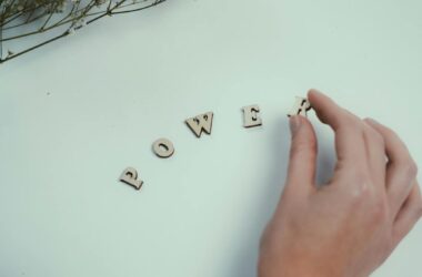 hand arranging wooden letters spelling power