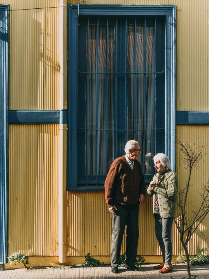 man and woman standing in front of building s window