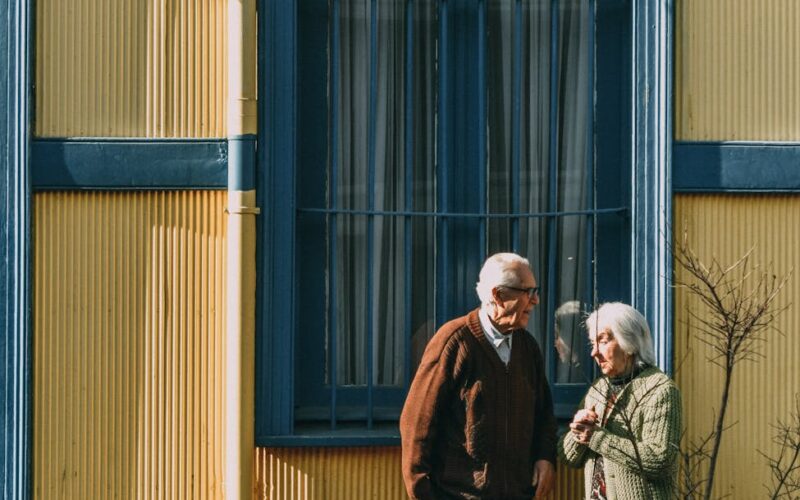 man and woman standing in front of building s window