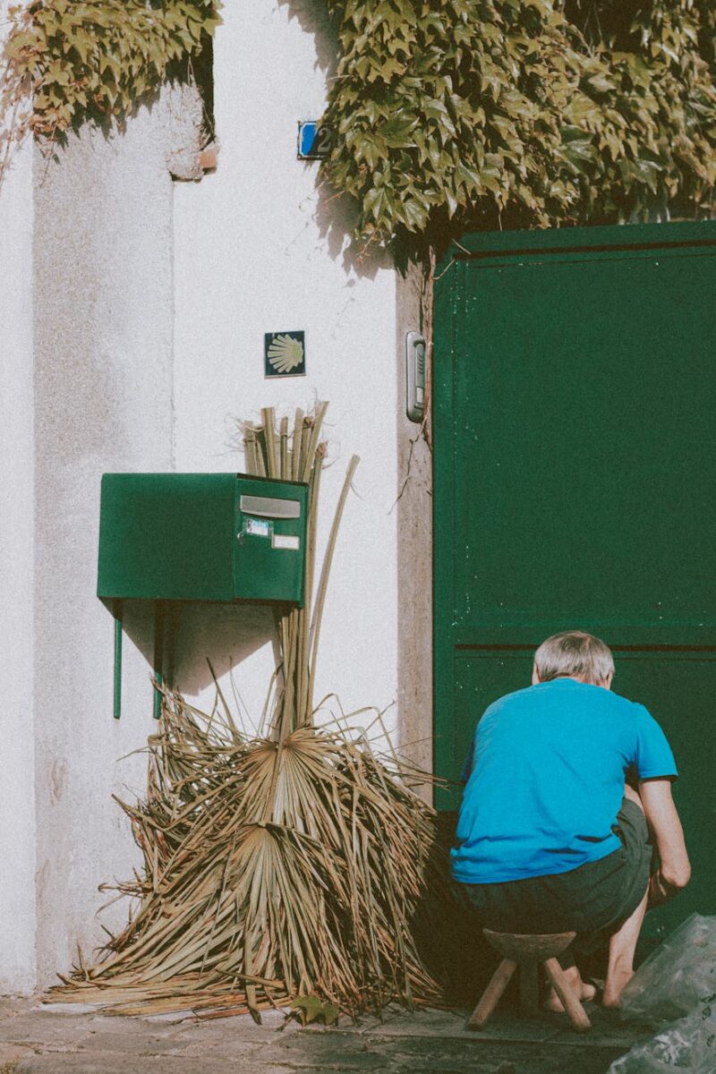 faceless man picking garbage in yard