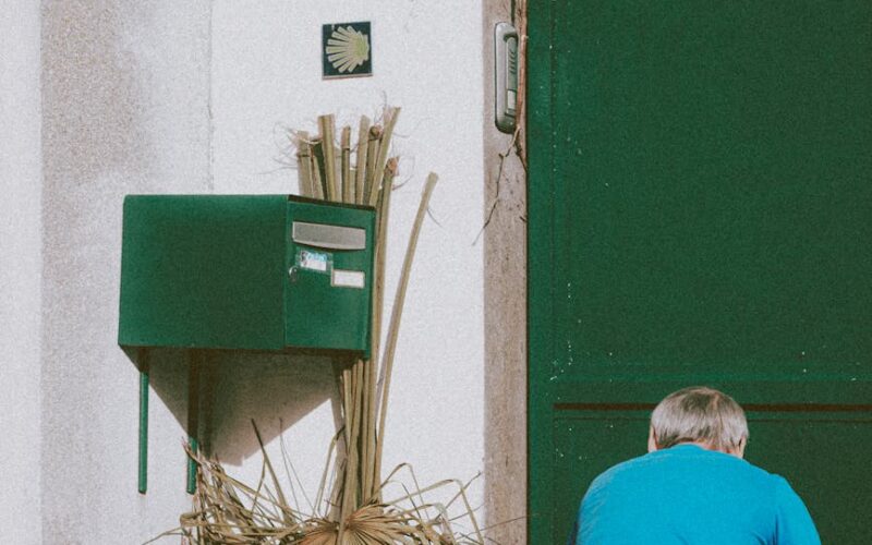 faceless man picking garbage in yard