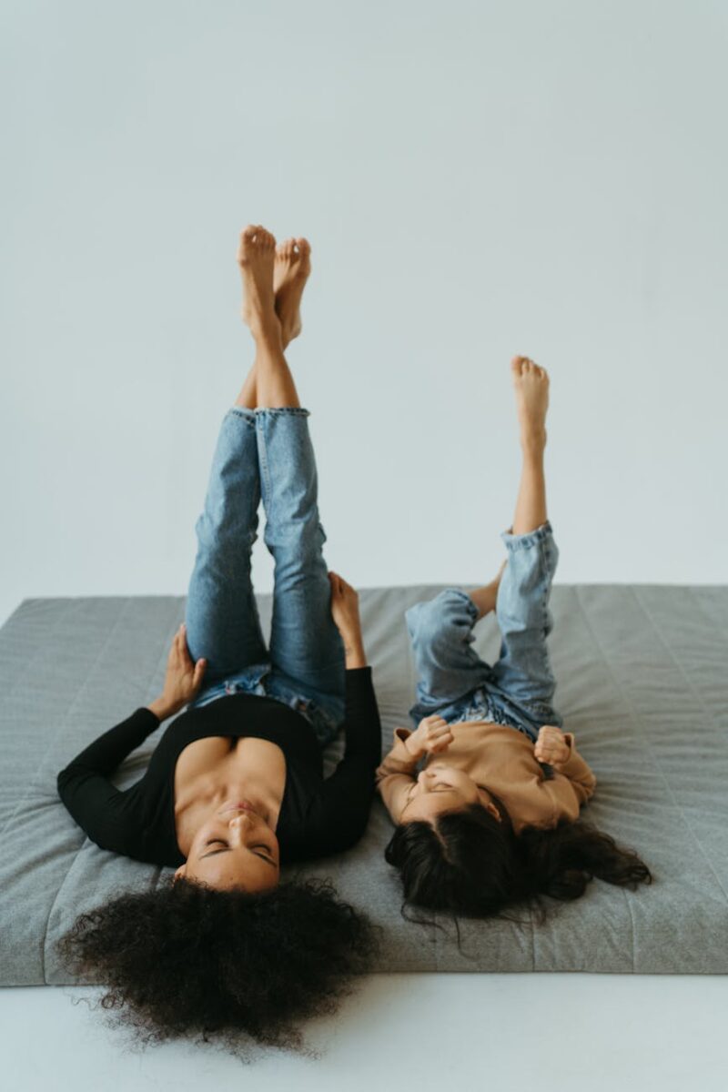 mother and daughter lying on the bed with legs up