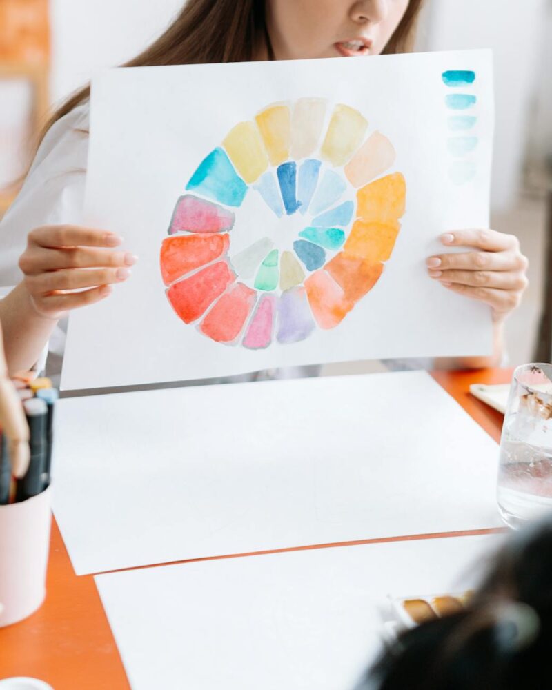 a woman holding white paper with rainbow color