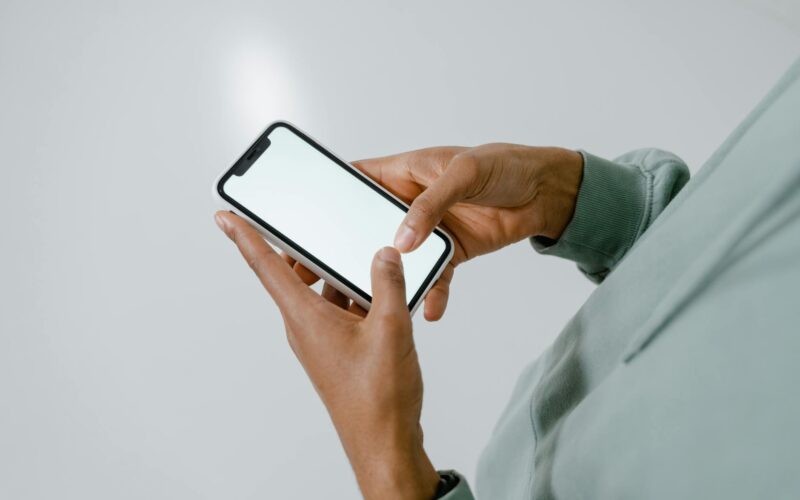 a person holding an iphone with blank screen