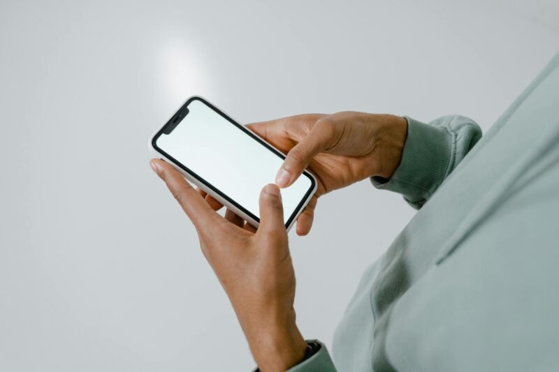 a person holding an iphone with blank screen